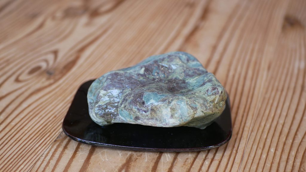 水を打った灰緑色の溜り石