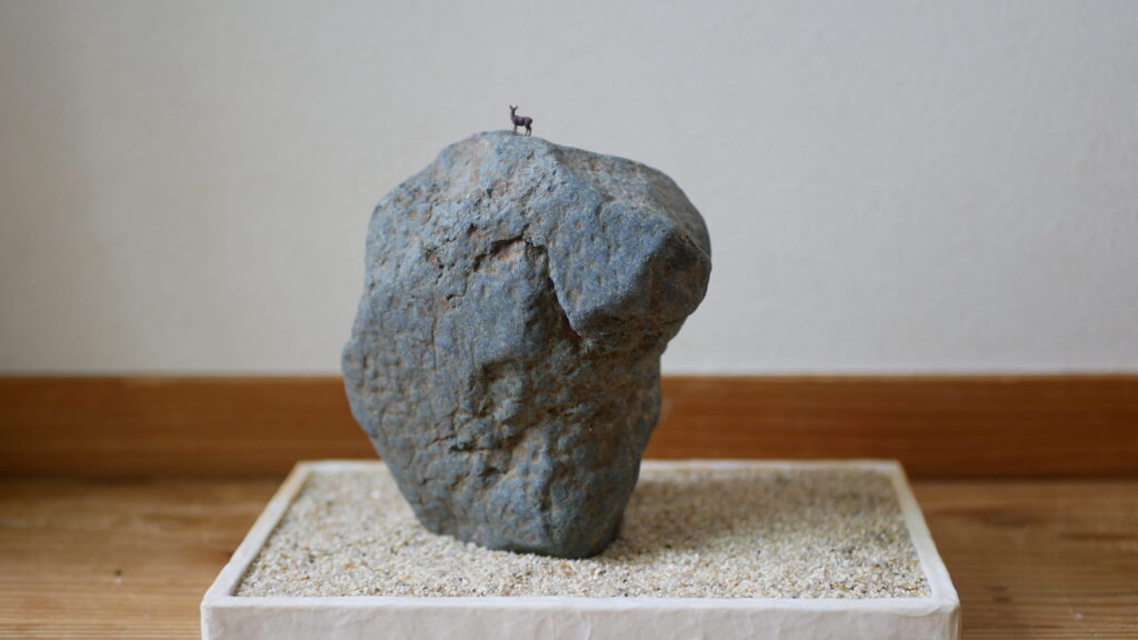 蒼黒の多摩川石に鹿さんを飾る